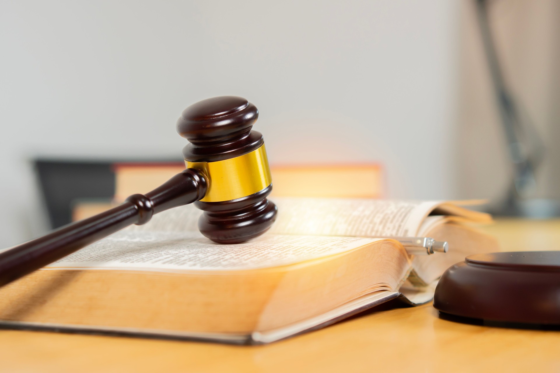 Judges gavel and book on wooden table in room. Symbolizing justice and legal authority concept.